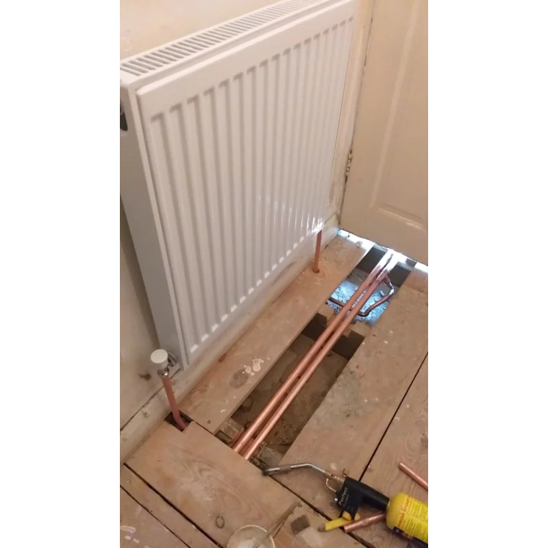 New radiator and central heating pipework under floorboards